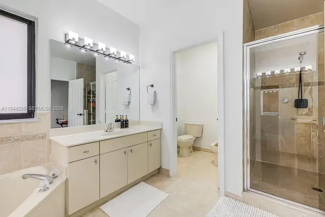 a spacious bathroom with a double vanity sink mirror and toilet