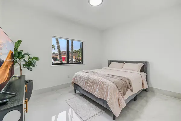 a bedroom with a bed and a potted plant