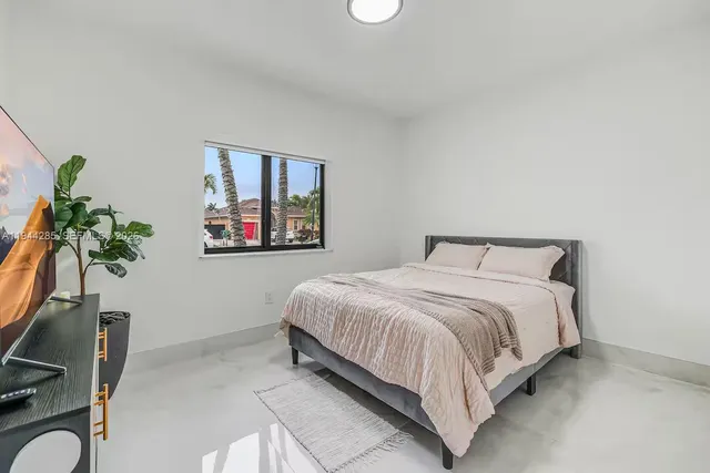 a bedroom with a bed and a potted plant