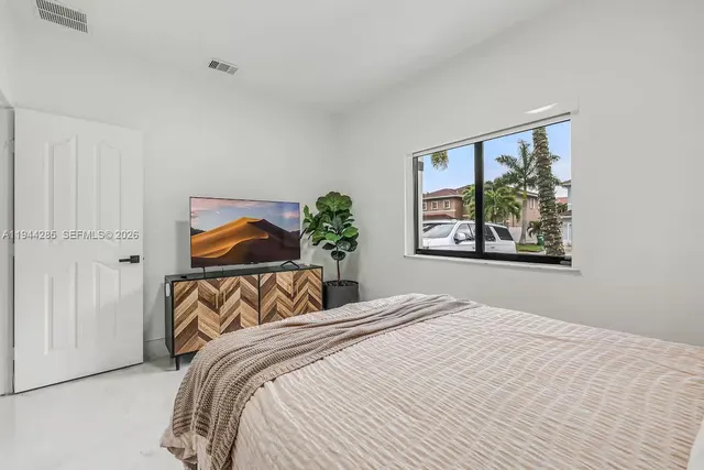 a bedroom with a large bed and a painting on the wall