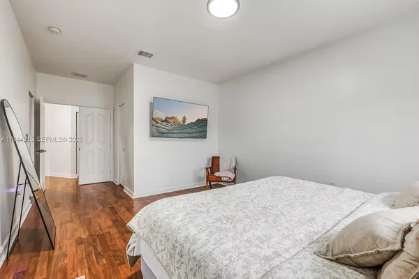 a bedroom with a large bed and a chandelier