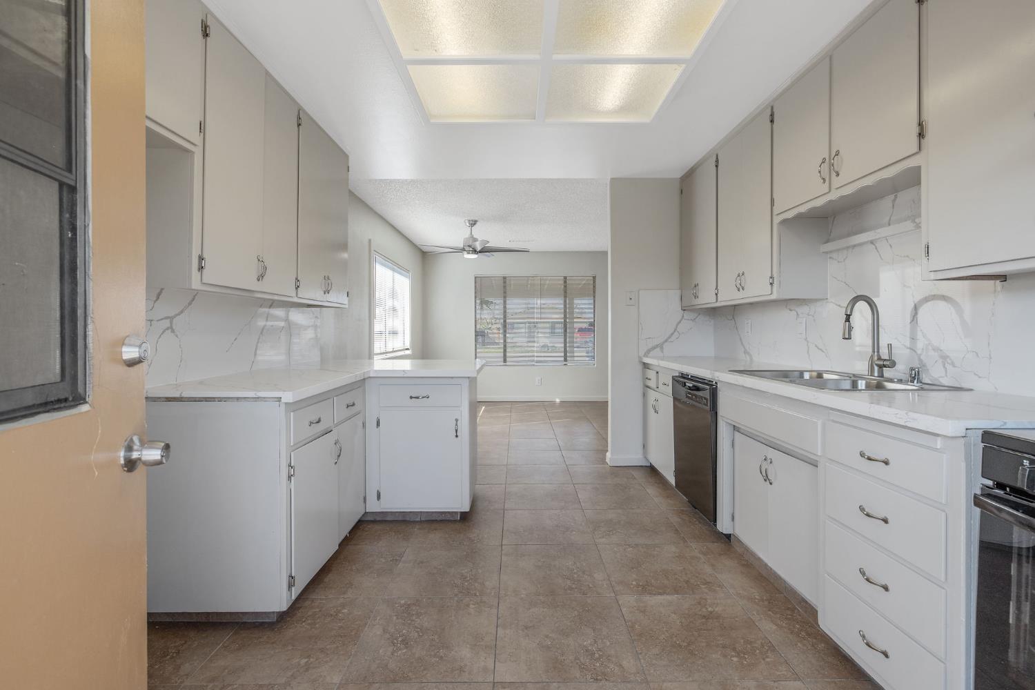 1432 North Locust Street Visalia, CA 93291 - Photo 12 of 37 a kitchen with white cabinets and white appliances