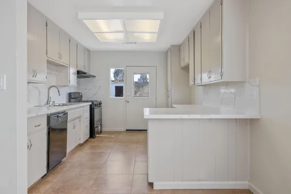 a kitchen with a sink cabinets and window