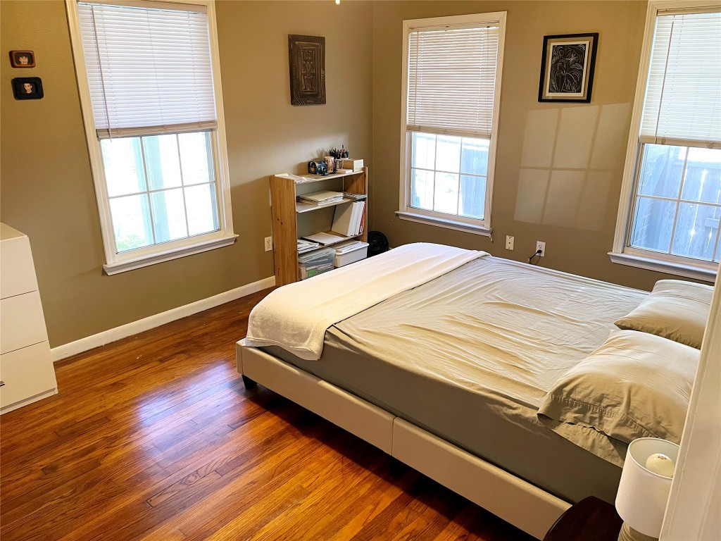 1131 Ebert Avenue Austin, TX 78721 - Photo 12 of 12 a bedroom with a bed and wooden floor