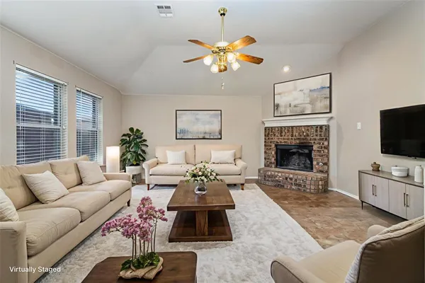 a living room with furniture a fireplace and a flat screen tv