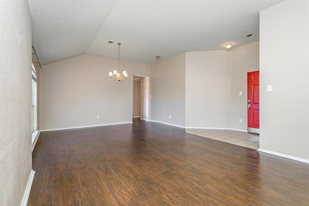 101 Wandering Drive Forney, TX 75126 - Photo 8 of 30 a view of an empty room with wooden floor and a ceiling fan