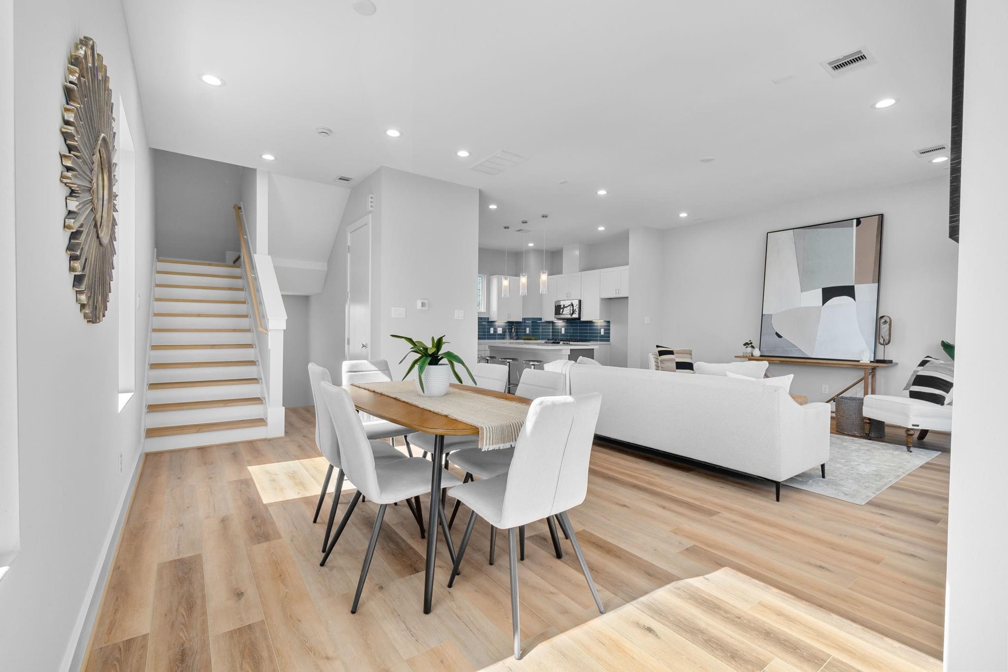 903 Quitman Street, Unit B Houston, TX 77009 - Photo 3 of 23 Dedicated dining space positioned alongside the living area, highlighted by large windows and a clean-lined staircase that enhances the home’s modern design.