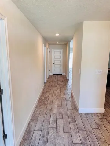a view of a hallway with wooden floor