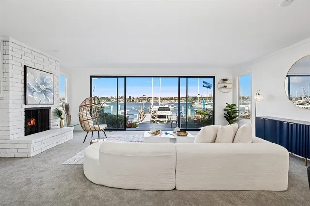 a living room with furniture a fireplace and a large window