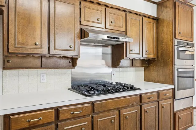 a kitchen with stainless steel appliances granite countertop a sink stove and cabinets