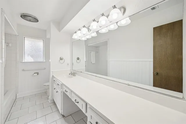 a spacious bathroom with a granite countertop sink a mirror and a shower