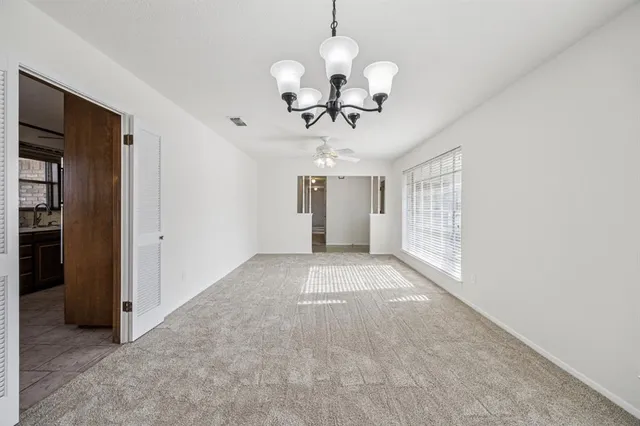 a view of a room with a chandelier fan and windows