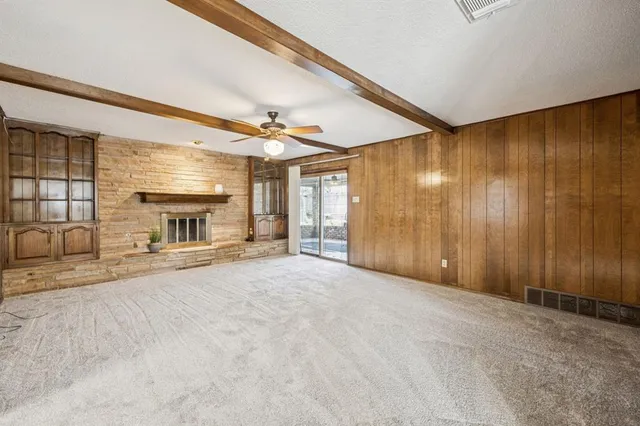 a view of an empty room with a fireplace and a chandelier