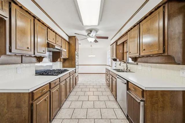 a kitchen with stainless steel appliances granite countertop a sink stove and cabinets