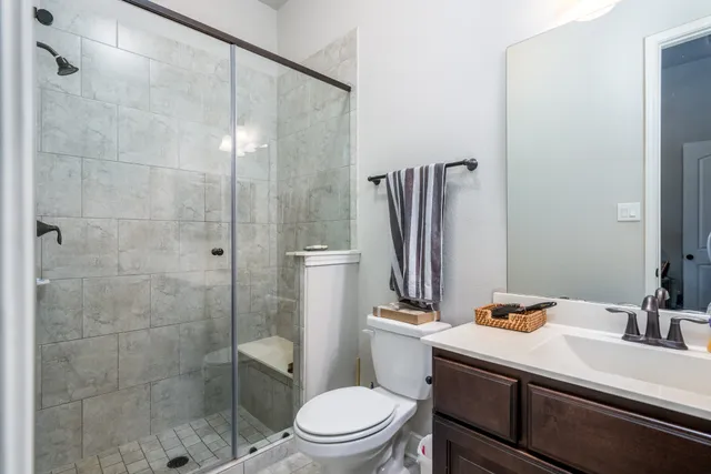 a bathroom with a sink a toilet and shower