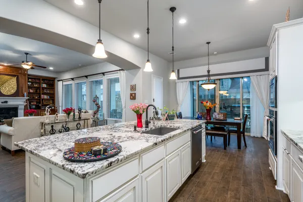 a kitchen with kitchen island a dining table and chairs