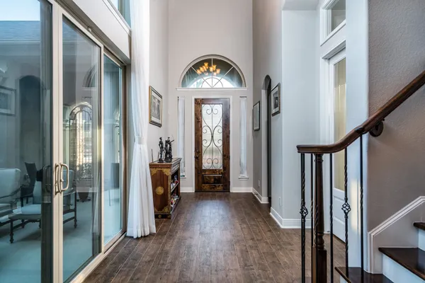 a view of a hallway with wooden floor and entryway