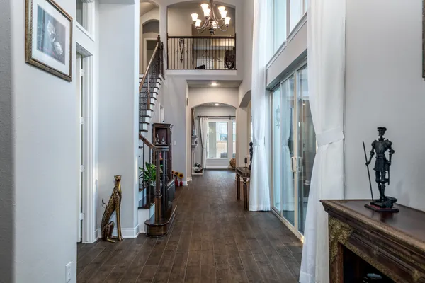 a view of a hallway with wooden floor and a livingroom