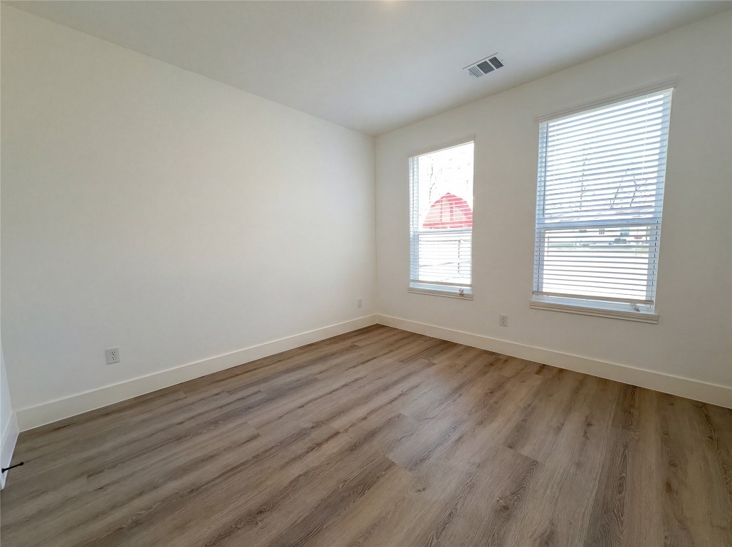 15376 Coaltown Road Willis, TX 77378 - Photo 12 of 17 an empty room with wooden floor and windows