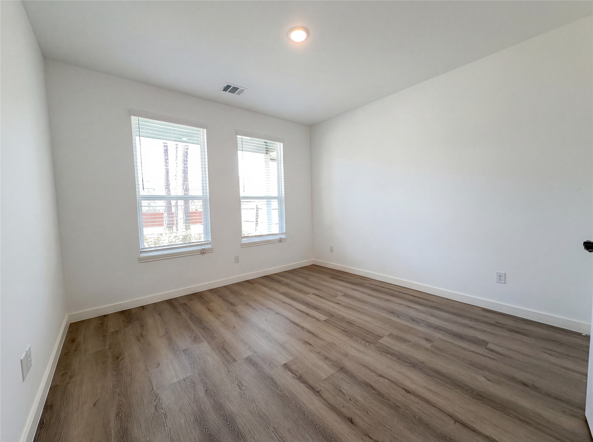 15376 Coaltown Road Willis, TX 77378 - Photo 14 of 17 an empty room with wooden floor and windows