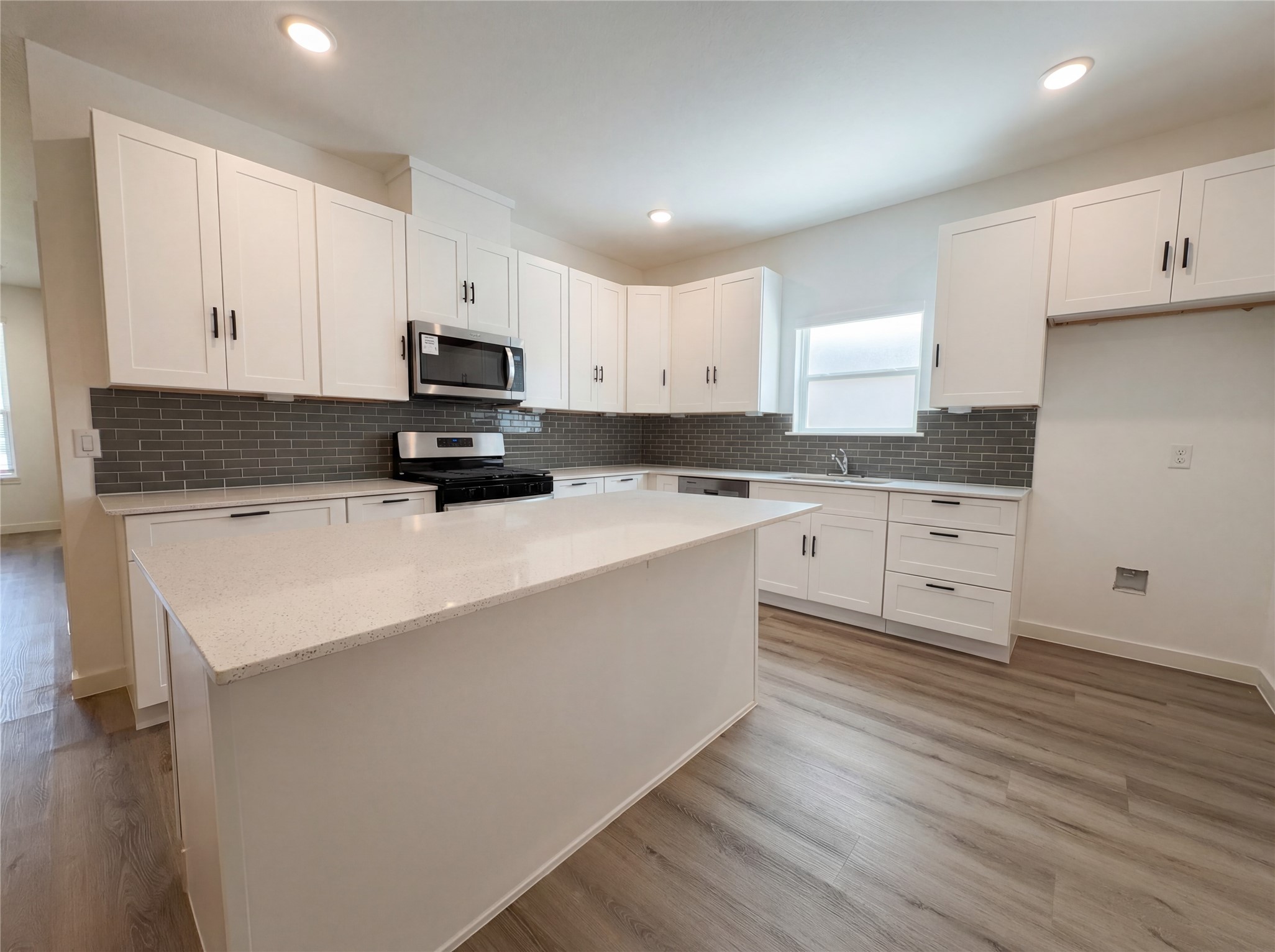 15376 Coaltown Road Willis, TX 77378 - Photo 9 of 17 a kitchen with granite countertop a sink a stove and cabinets