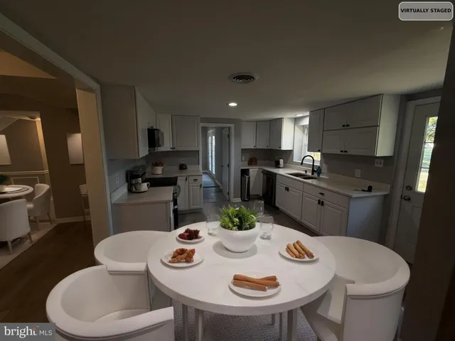 a kitchen with stainless steel appliances a dining table and chairs