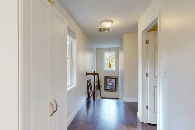 a view of a hallway with wooden floor and windows
