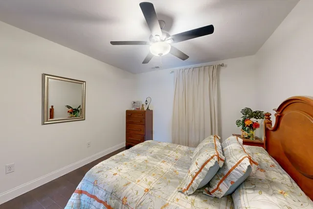 a bedroom with bed and wooden floor