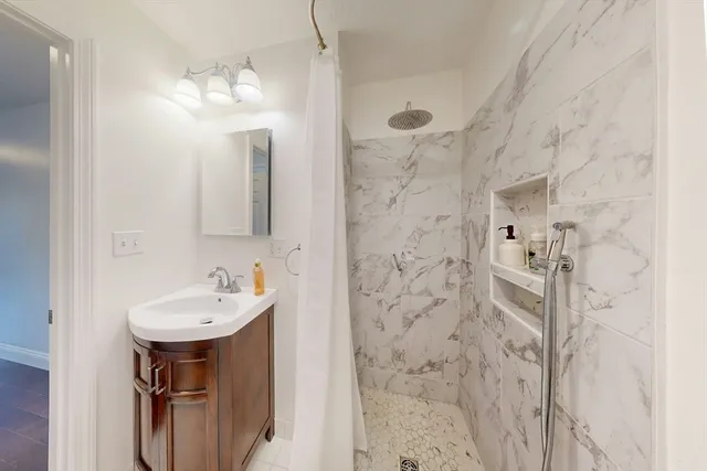 a bathroom with a sink a mirror and shower