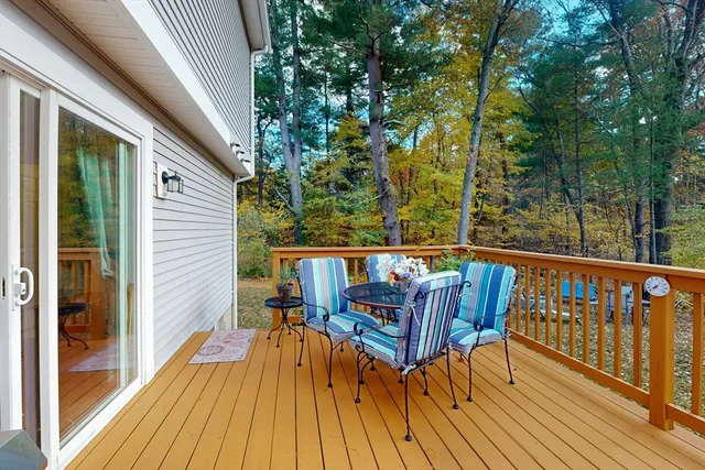 a balcony with wooden floor table and chairs