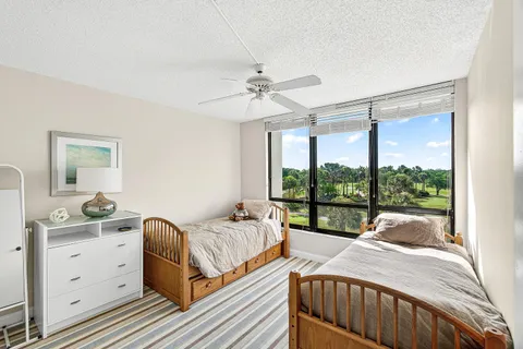 a bedroom with a bed and a dresser next to a window