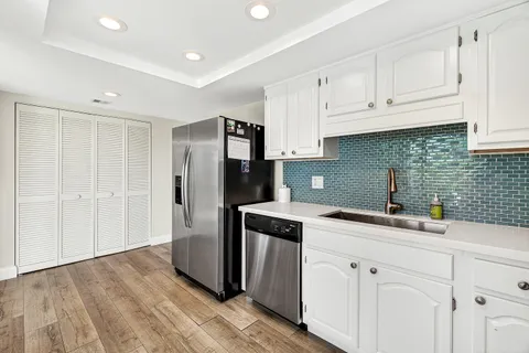 a kitchen with a sink dishwasher a refrigerator and cabinets