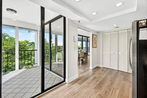 a view of hallway with a floor to ceiling window and wooden floor