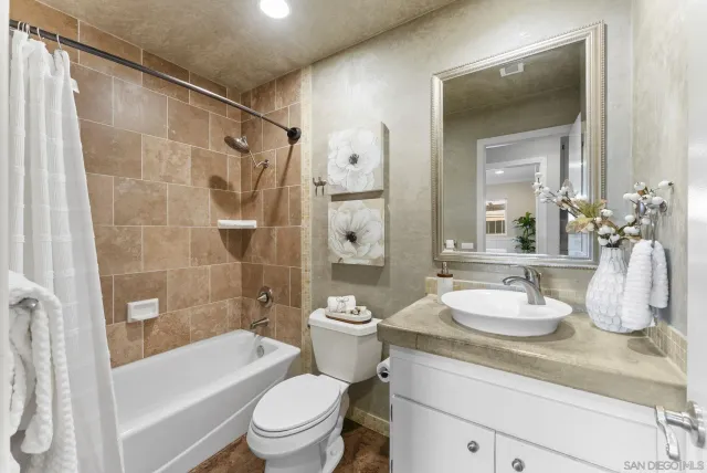 a bathroom with a granite countertop sink toilet a shower and a mirror