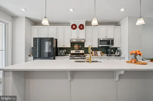 a kitchen with a sink a counter space dining table and chairs