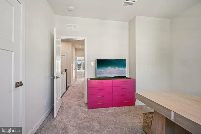 a bedroom with a bed and a flat tv screen on dresser