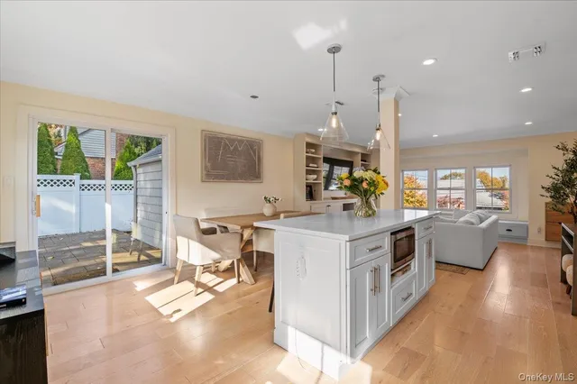 a kitchen with kitchen island a counter top space a sink stainless steel appliances and cabinets