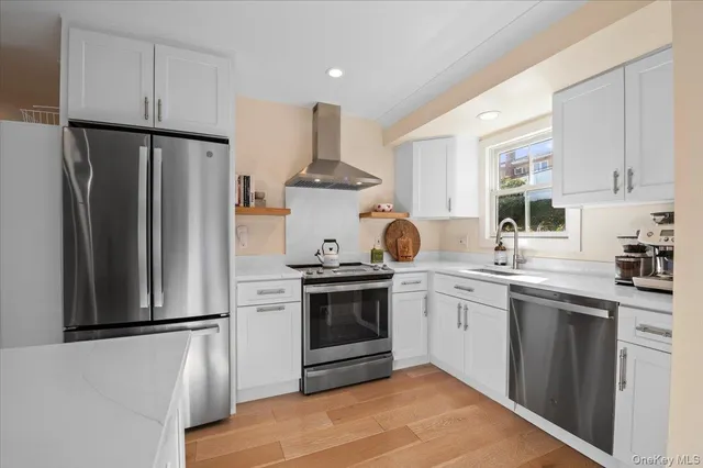 a kitchen with stainless steel appliances granite countertop a stove oven and a refrigerator with white cabinets