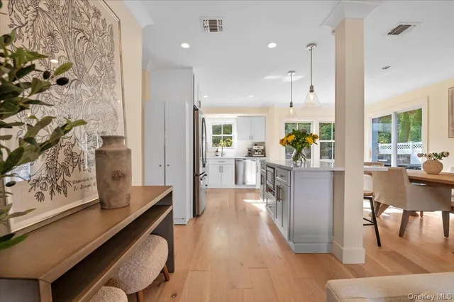 a living room with stainless steel appliances kitchen island granite countertop furniture and a rug