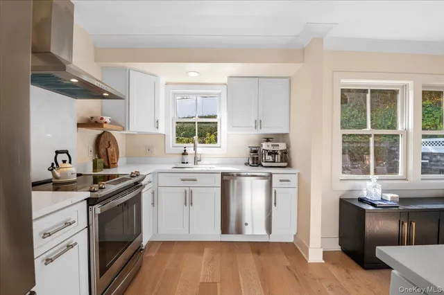 a kitchen with a stove a sink and a window