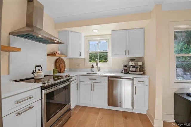 a kitchen with stainless steel appliances granite countertop a sink a stove and cabinets