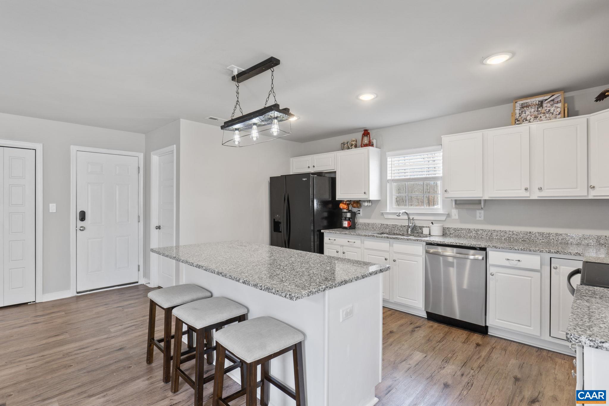1075 Pine Crest Drive Troy, VA 22974 - Photo 13 of 25 a kitchen with stainless steel appliances granite countertop a kitchen island hardwood floor sink stove dining table and chairs