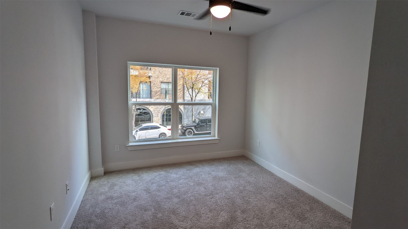 2500 Longview Street, Unit 218 Austin, TX 78705 - Photo 10 of 19 Carpeted Master bedroom with ceiling fan and baseboards