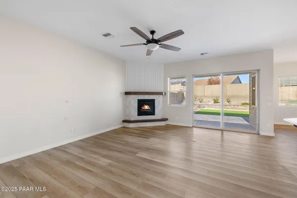 a view of an empty room with a fireplace and a window