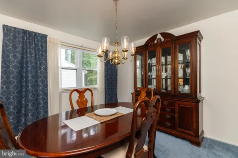 a dining room with furniture a chandelier and window