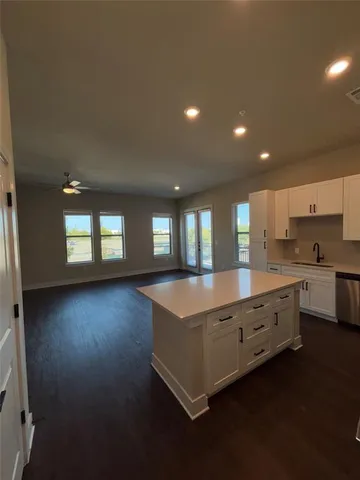 a large kitchen with kitchen island white cabinets and wooden floor
