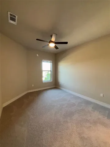 a view of empty room with a ceiling fan and window