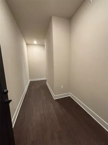 a view of a room with wooden floor and white walls