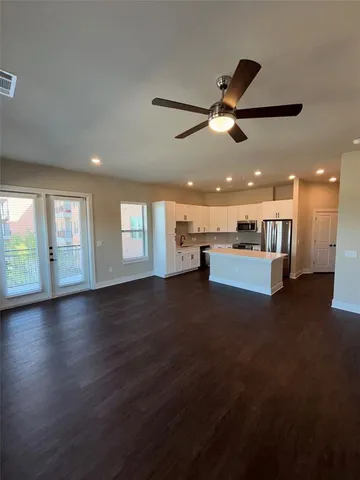a view of a hall with kitchen and living room