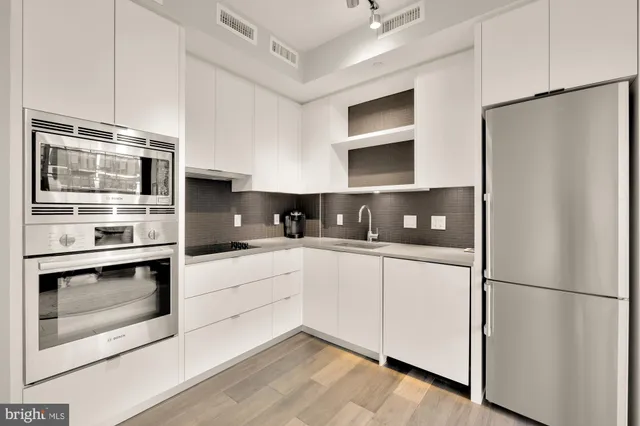 a kitchen with stainless steel appliances a refrigerator sink and microwave